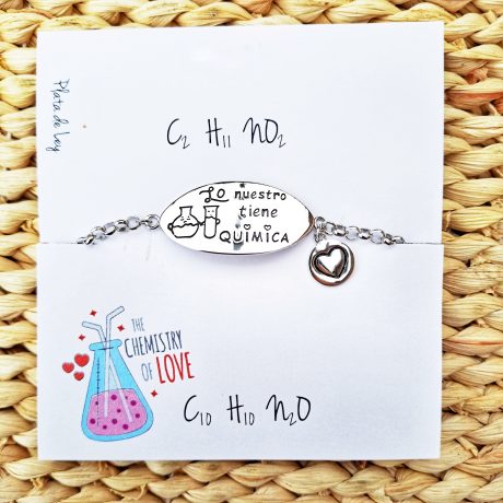 Pulsera de plata con una chapa ovalada en el centro donde esta grabado ( lo nuestro tiene quimica) a un lado de la pulsera cuelga una pequeña chapa con corazon grabada en el centro