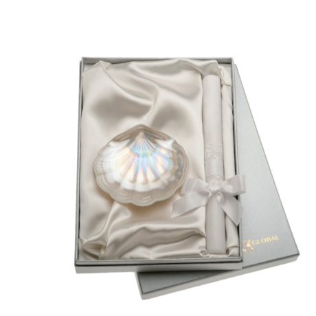 El Set de Concha y Vela Blanca contiene una preciosa concha nacarada y una vela bautismal decorada  con un preciso lazo blanco y toto viene presentado en una estuche forrado de raso