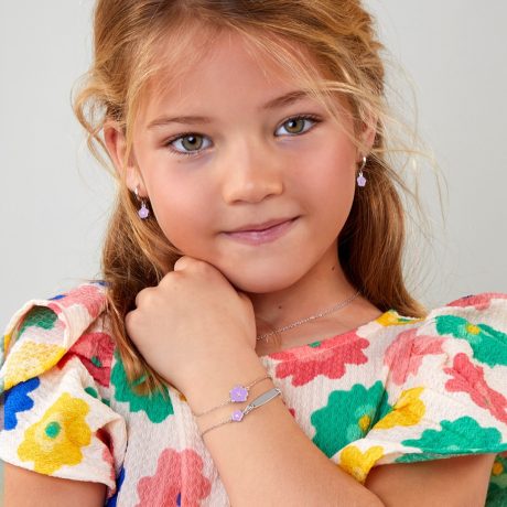 Niña con el conjunto de joyas de plata con una flor esmaltada en lila