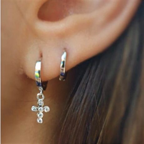Los Pendiente  Cruz de plata son unos  precioso pendiente de aro con cierre de clip con un pequeña cruz con cuatro circonitas en posición vertical y tres circonitas en posición horizontal Características : Diámetro del aro  11.3 mm Altura de  la  Cruz   8 mm Ancho de la Cruz  6 mm Incluye tuerca de presión de plata Fabricados en Plata de Ley 925 . Luce estilo y elegancia con nuestros Pendientes Cruz de plata. Unos preciosos aros con cierre de clip que destacan con una circonita negra. ¡Compra ahora!