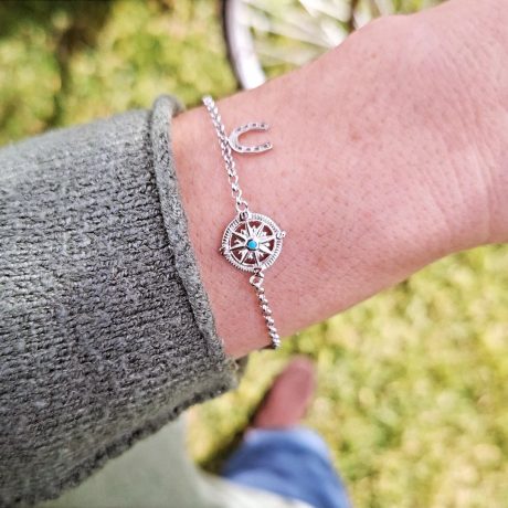 La Pulsera Rosa del viento de Plata es una pulsera de cadena, con motivo central de una rosa del viento   y al lado un colgando un pequeña herradura. Todo fabricado en  PLATA DE LEY 925. Esta pulsera viene presentada en un cartoncito ilustrado con la frase (YA SABES EL CAMINO, QUE NADA TE DETENGA ) Medidas de la  Pulsera Rosa del viento de Plata Longitud de pulsera 15.5 cm Diámetro de la Rosa del Viento 13 nm Ancho de la herradura 7.6 mm Altura de la herradura 9 mm Extensión  3.5 cm Descubre la elegancia de la Pulsera Rosa del viento de Plata con su diseño único de rosa del viento y herradura. Hazla tuya y brilla con estilo!