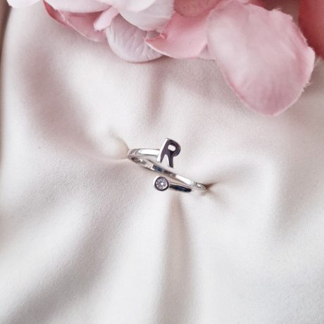El Anillo inicial  R de plata, es un anillo con un elegante diseño de dos líneas de circonitas transparentes en la casi todo el aro, lo que le da un brillo espectacular. Características  del Anillo inicial R de plata  : Ancho de aro: 1.7 mm Espesor del aro: 1.2 mm Altura de la inicial 5.4 mm Diámetro de circonitas 3.3 mm Plata de Ley 925 Descubre el brillo elegante del Anillo inicial R de plata con circonitas transparentes. Elige anillos ajustables y acierta en tu regalo.
